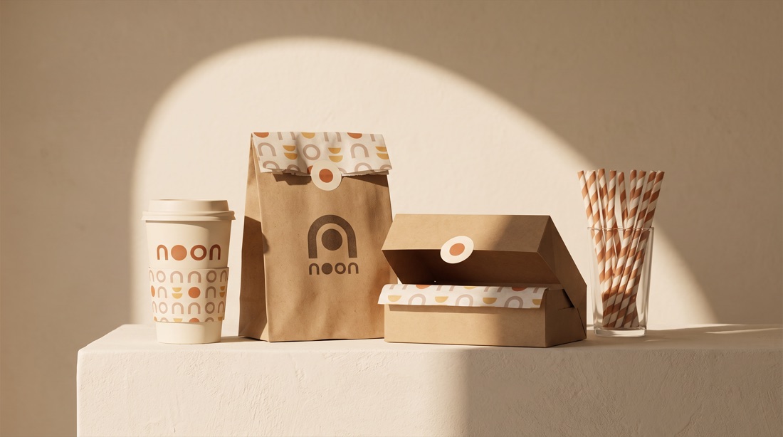 noon packaging on a plaster plinth: kraft bread bag, cups and a pastry box